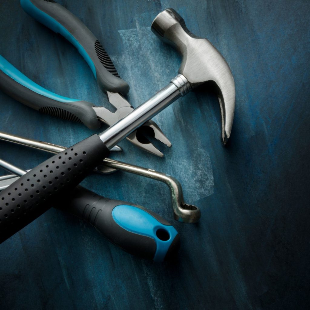 Hammer, pliers and other tools in a pile, cover image for basic home tool kit post