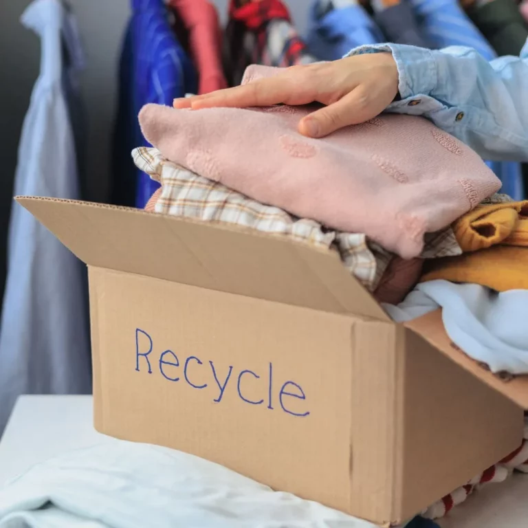 A box that says "recycle" on the side with clothes folded inside